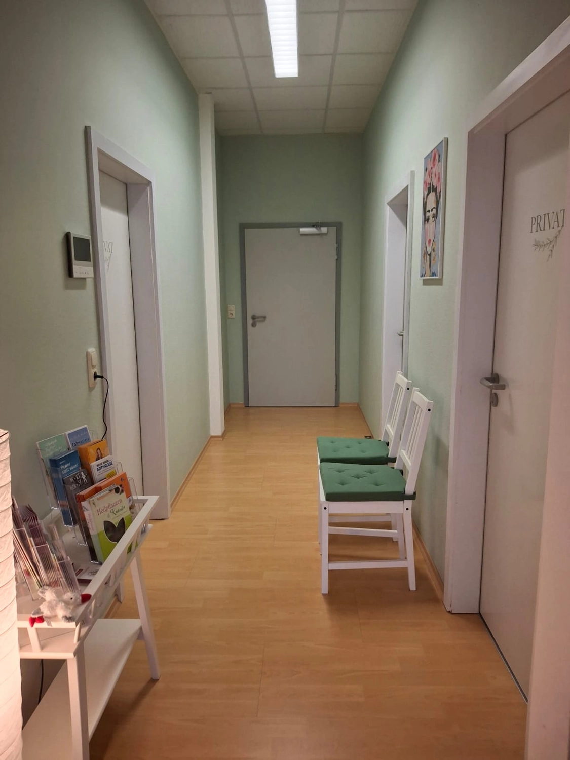 Flur der Naturheilpraxis mit Sitzgelegenheit und Zugang zu den Behandlungsräumen