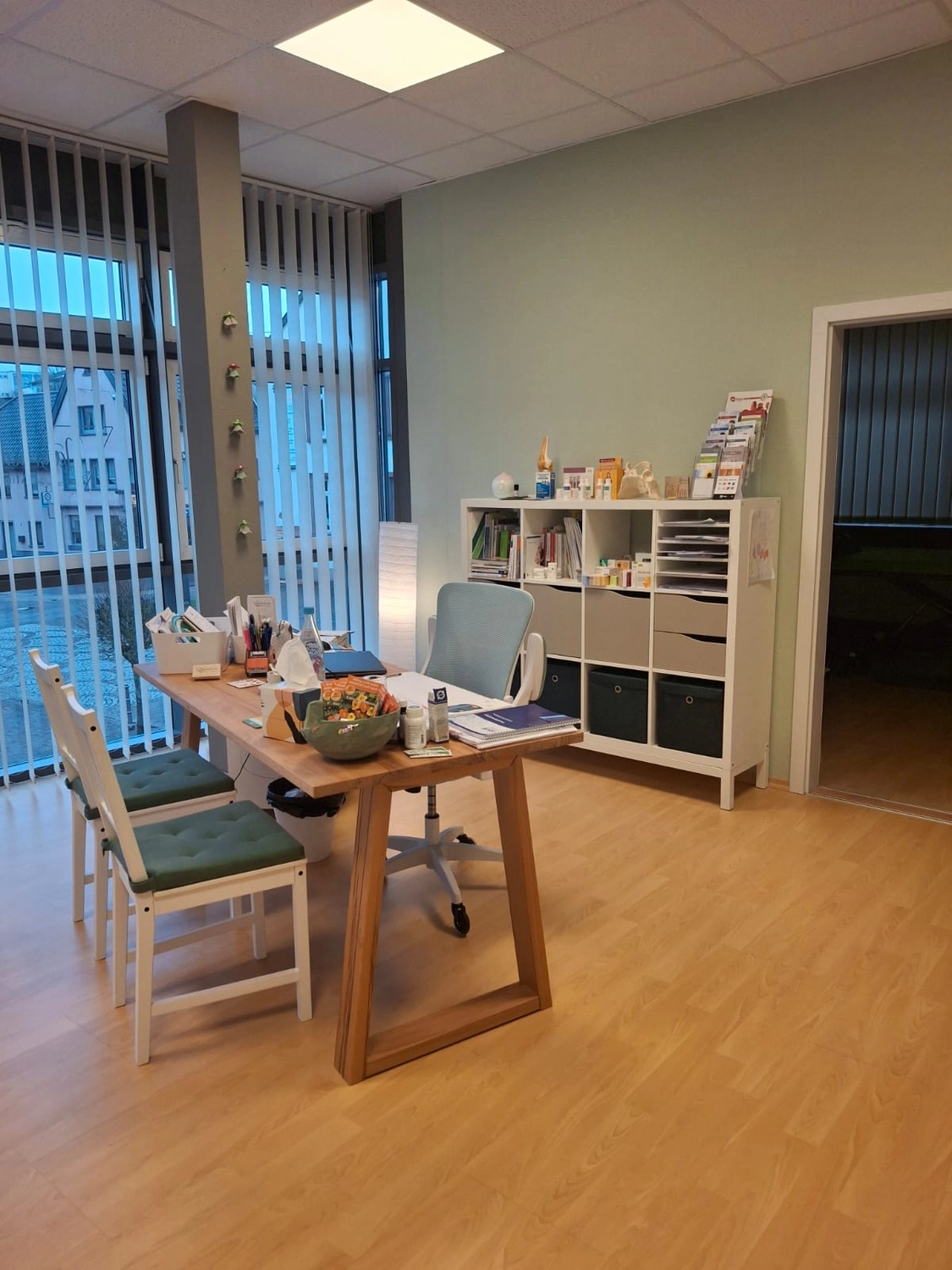 Büro- und Beratungsraum mit Schreibtisch und Regal
