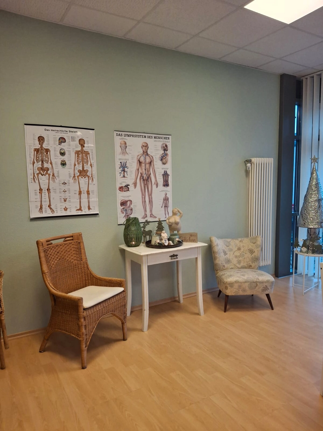 Wartebereich mit anatomischen Schautafeln und Sitzecke